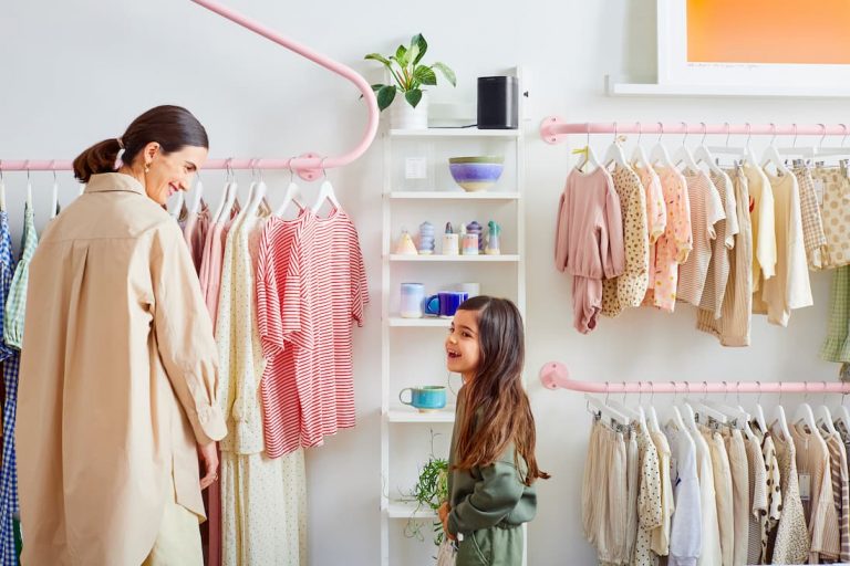 A mother and child shopping at a trendy retail store with a Sonos One speaker mounted on the wall providing background music with Sonos for business.