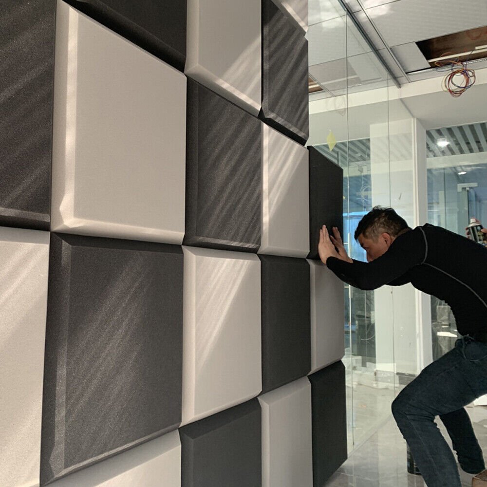 A business owner installs sound proof panels on the wall of his retail location in order to improve acoustics.