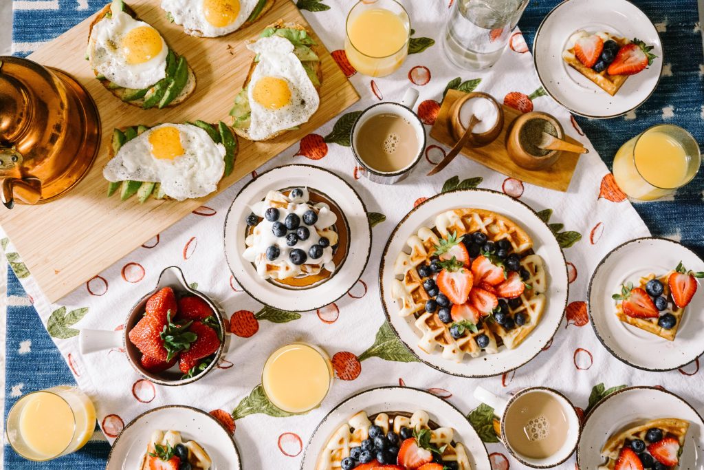 A brunch table is shown with an array of breakfast foods paired with bottomless mimosas.