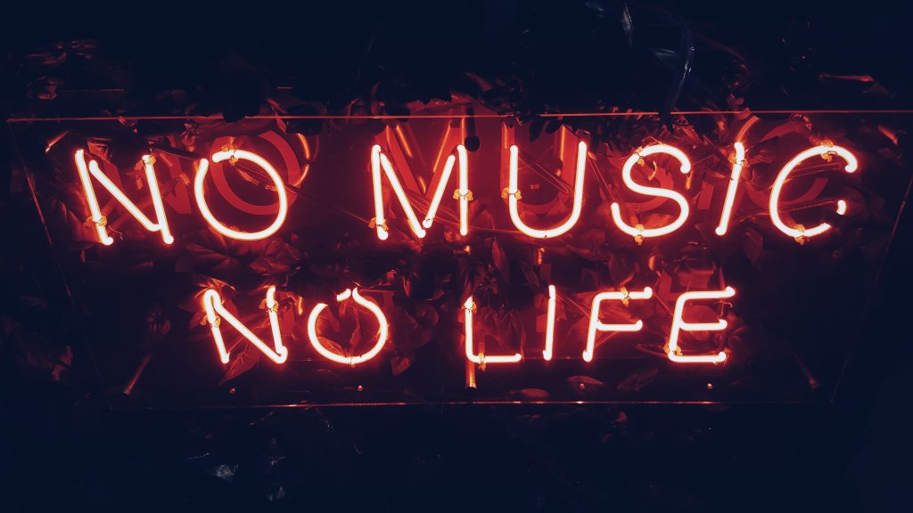 A neon sign glows the colour red with the words "No Music, No Life"