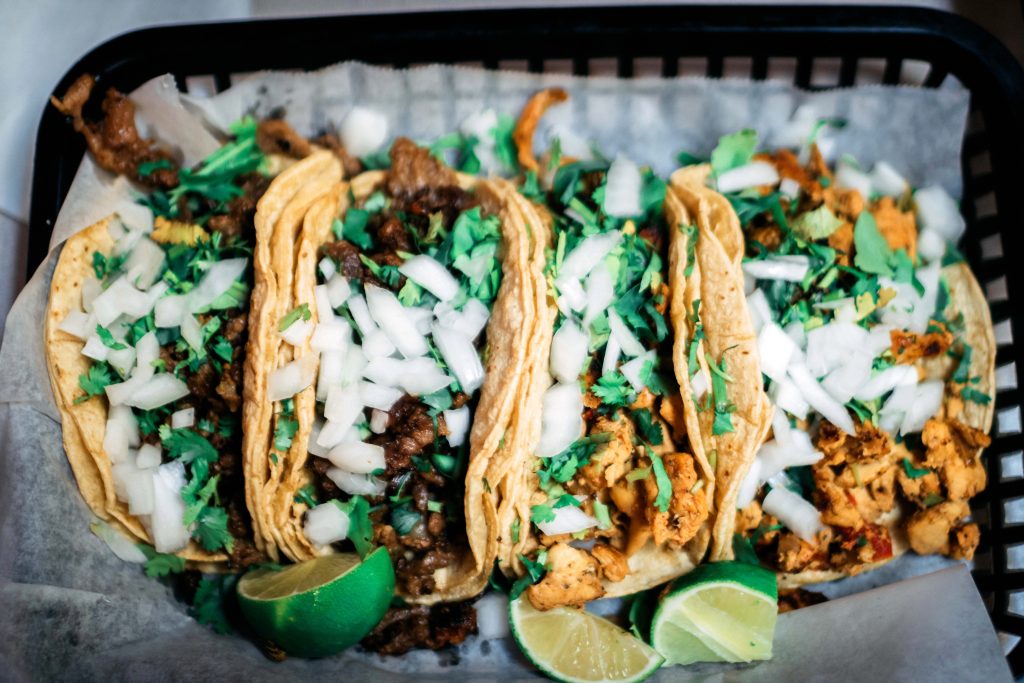 Corn tortilla tacos are shown, with fresh toppings. Prepped for Taco Tuesday at a local restaurant.