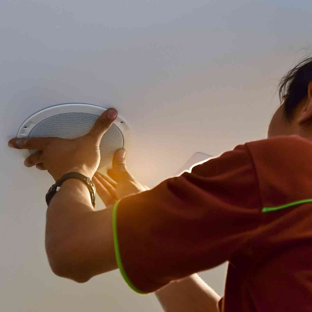 An audio installer is shown installing a speaker system for a new business.