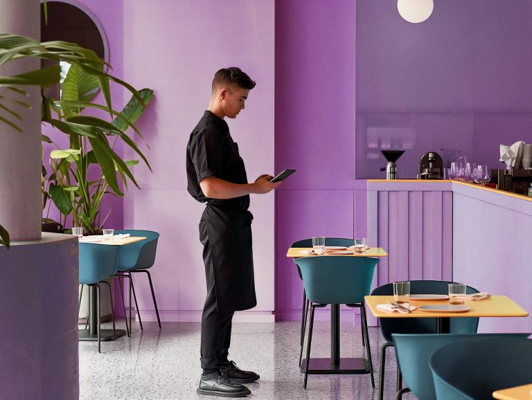 staff member in the middle of the restaurant making music adjustments from a smartphone